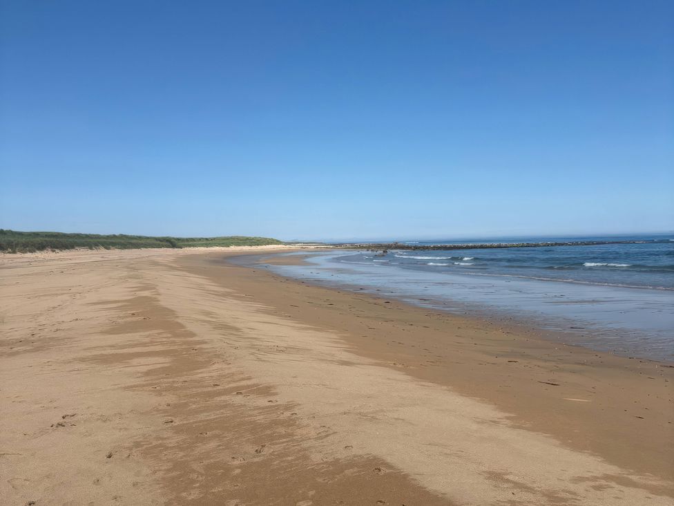 A beach extending along the shoreline near the ocean at Viola Cottage St Combs near Fraserburgh