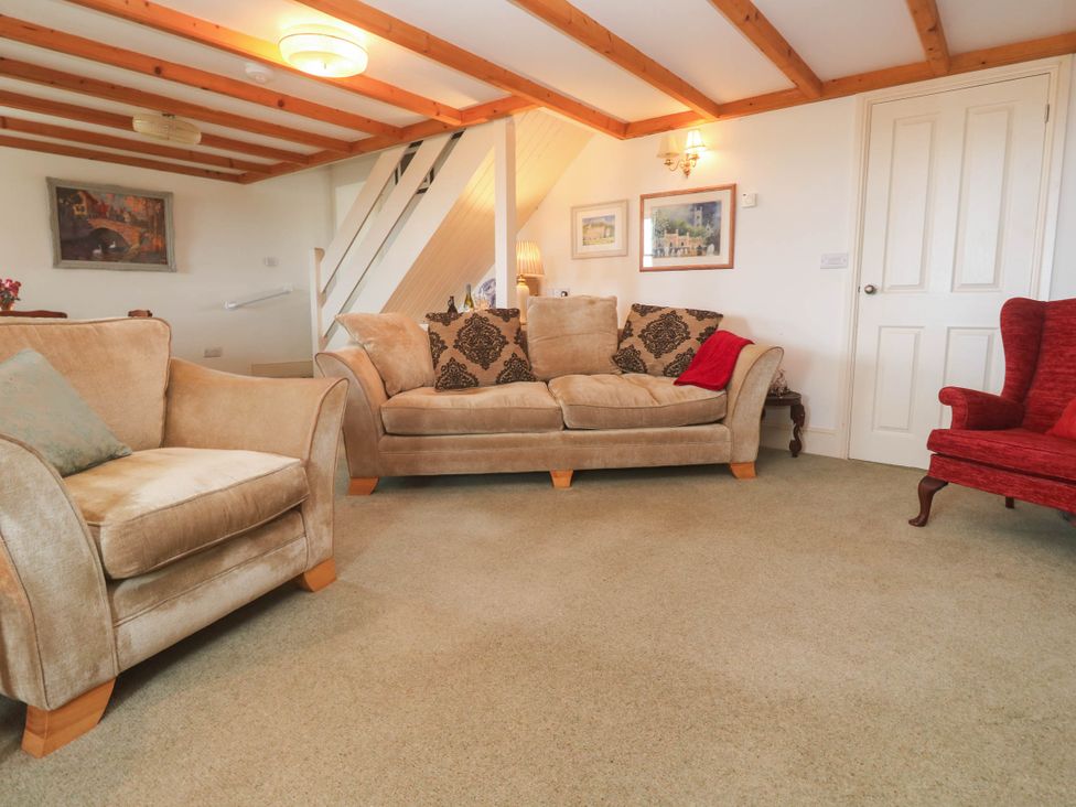 A living room with seating and artwork at Chyrose Farmhouse in Pendeen