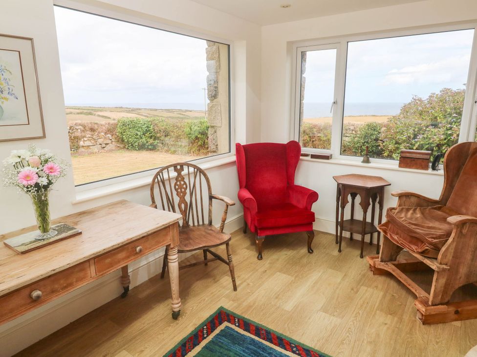 A snug with a wooden table and chairs at Chyrose Farmhouse in Pendeen
