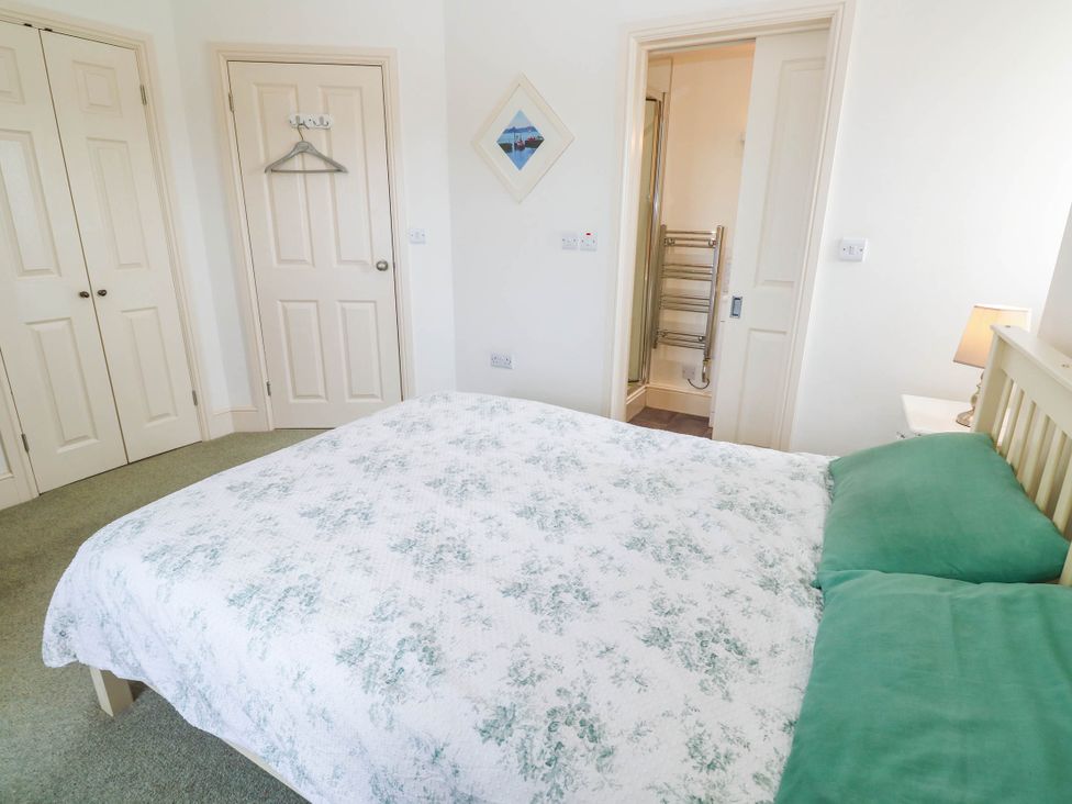 A bedroom with a bed and closet doors at Chyrose Farmhouse in Pendeen