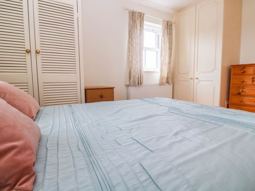 A bedroom with a bed and chest of drawers at Chyrose Farmhouse in Pendeen