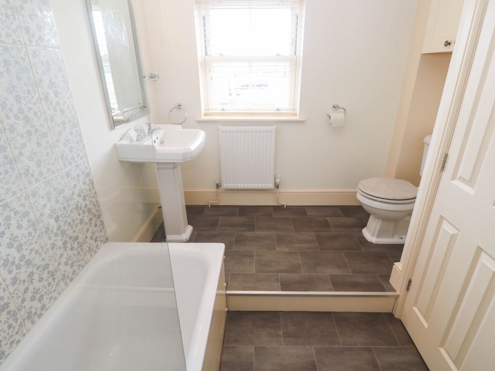 A bathroom with a bathtub, sink, and toilet at Chyrose Farmhouse in Pendeen