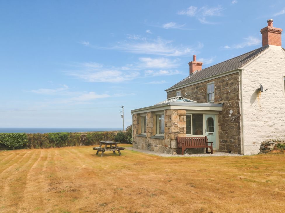 A house with a bench and table in the outdoor area at Chyrose Farmhouse, Pendeen
