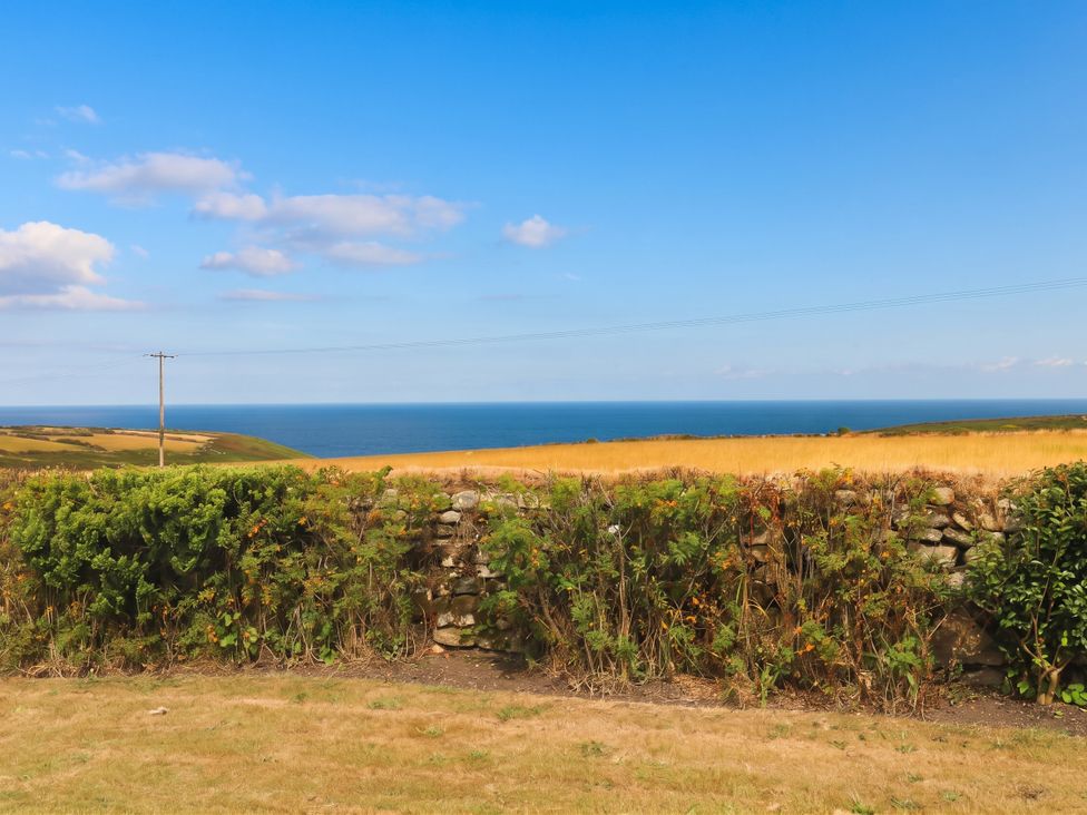 A landscape view of the ocean and fields at Chyrose Farmhouse in Pendeen
