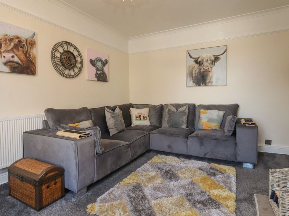A living room with a gray sofa and wall art at 10 Oak Street in Keighley
