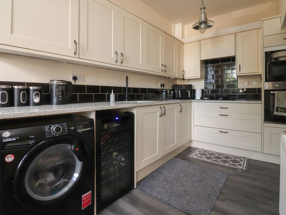 A kitchen with a washing machine and wine cooler at 10 Oak Street in Keighley