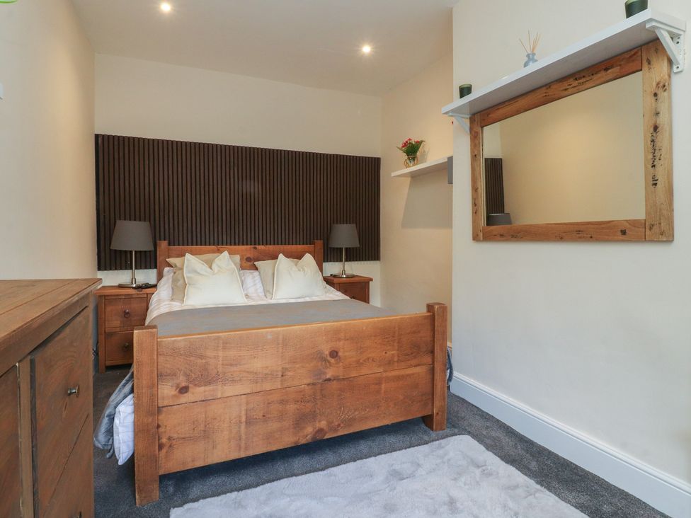 A bedroom with a wooden bed and nightstands at 10 Oak Street in Keighley