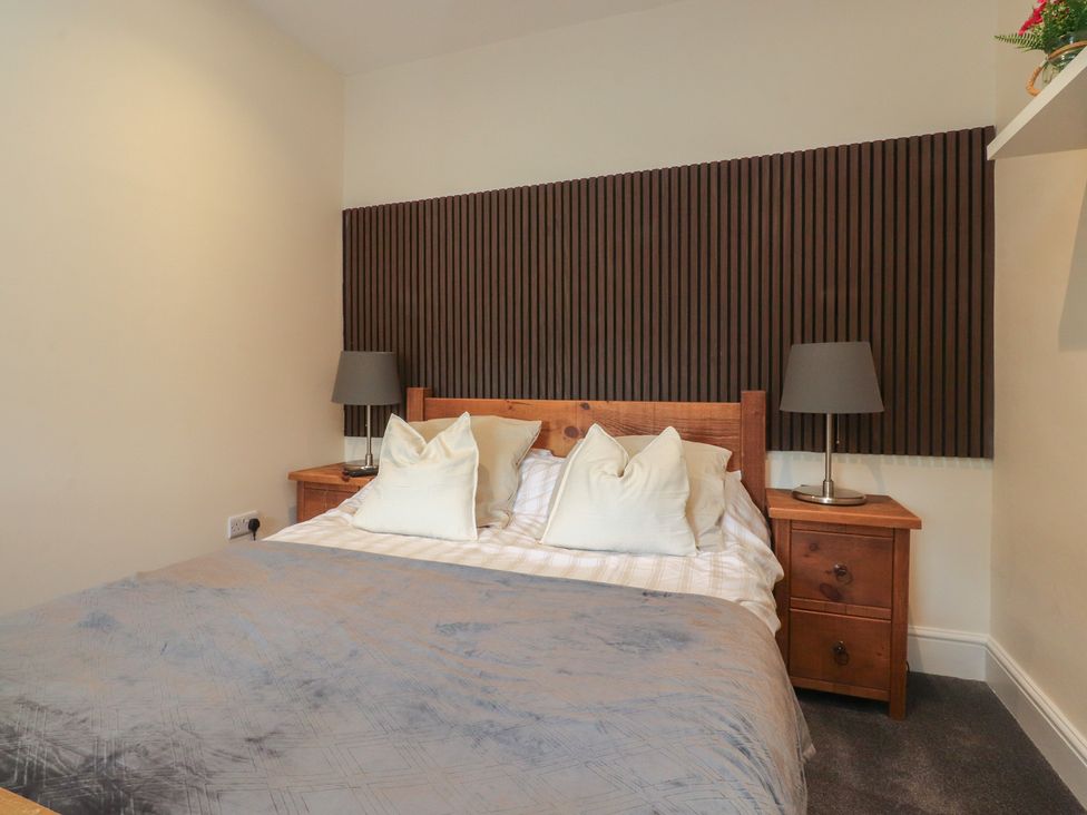 A bedroom with a bed and nightstands at 10 Oak Street in Keighley