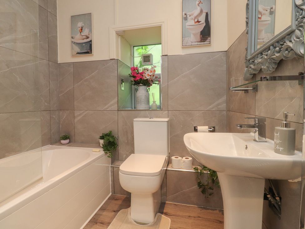 A bathroom featuring a bathtub, toilet, and sink at 10 Oak Street in Keighley