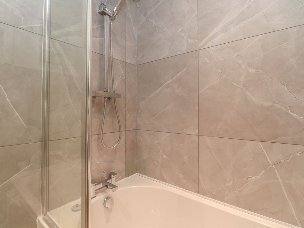 A bathroom with a shower and bathtub at 10 Oak Street in Keighley