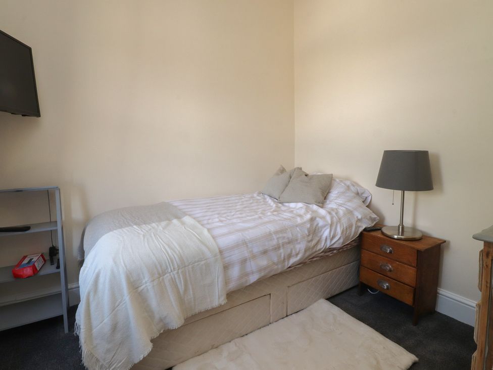 A bedroom with a bed, lamp, and television at 10 Oak Street in Keighley
