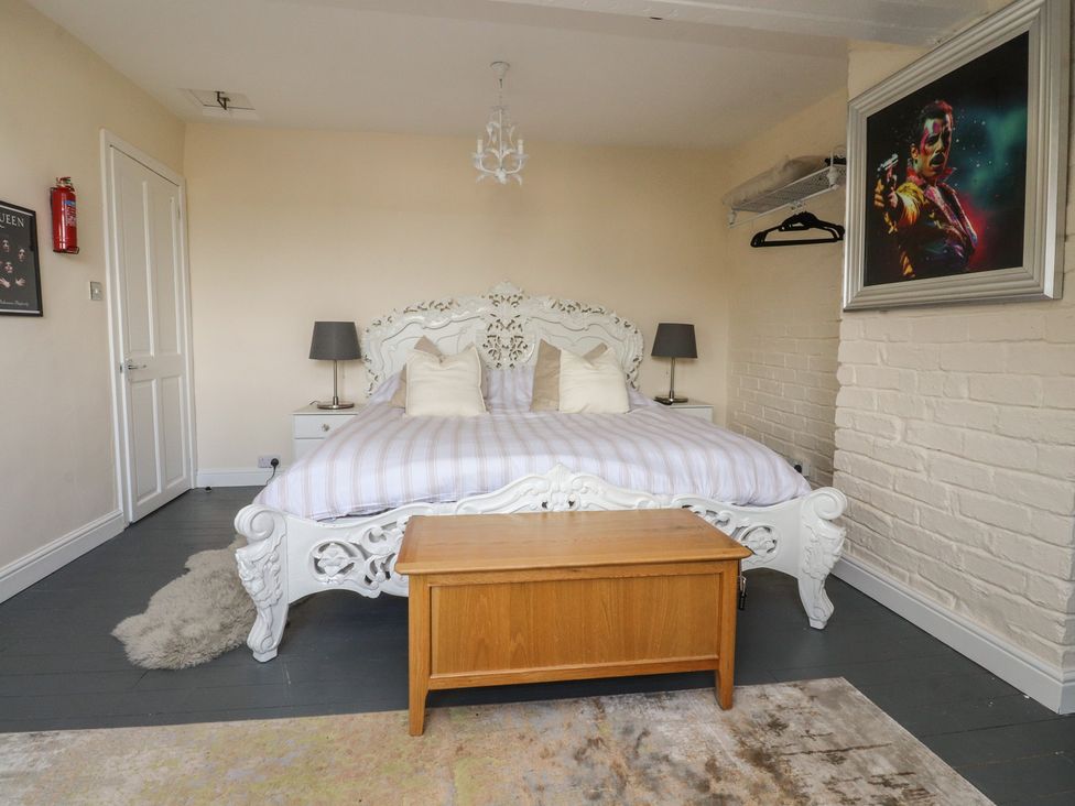 A bedroom with a bed and nightstands at 10 Oak Street in Keighley