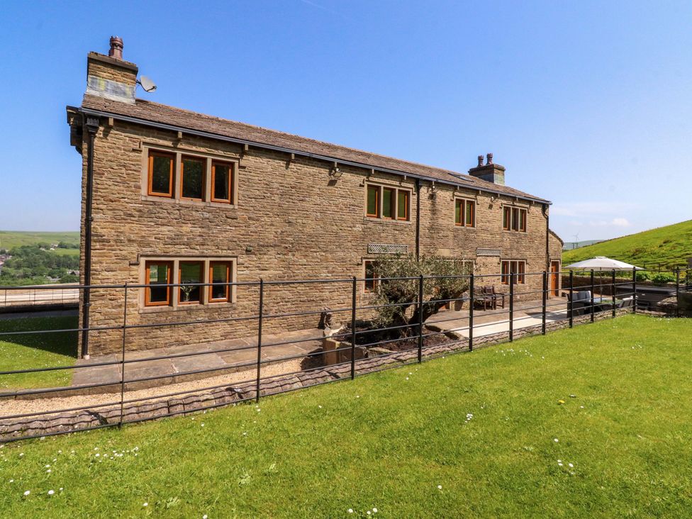 A house with a fenced garden and pathway at Sheephouse Farm in Bacup