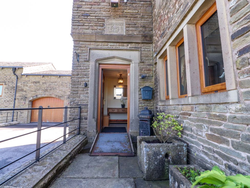 An entrance with a door and light fixture at Sheephouse Farm in Bacup