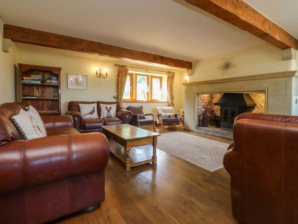A living room with a fireplace and bookshelves at Sheephouse Farm in Bacup