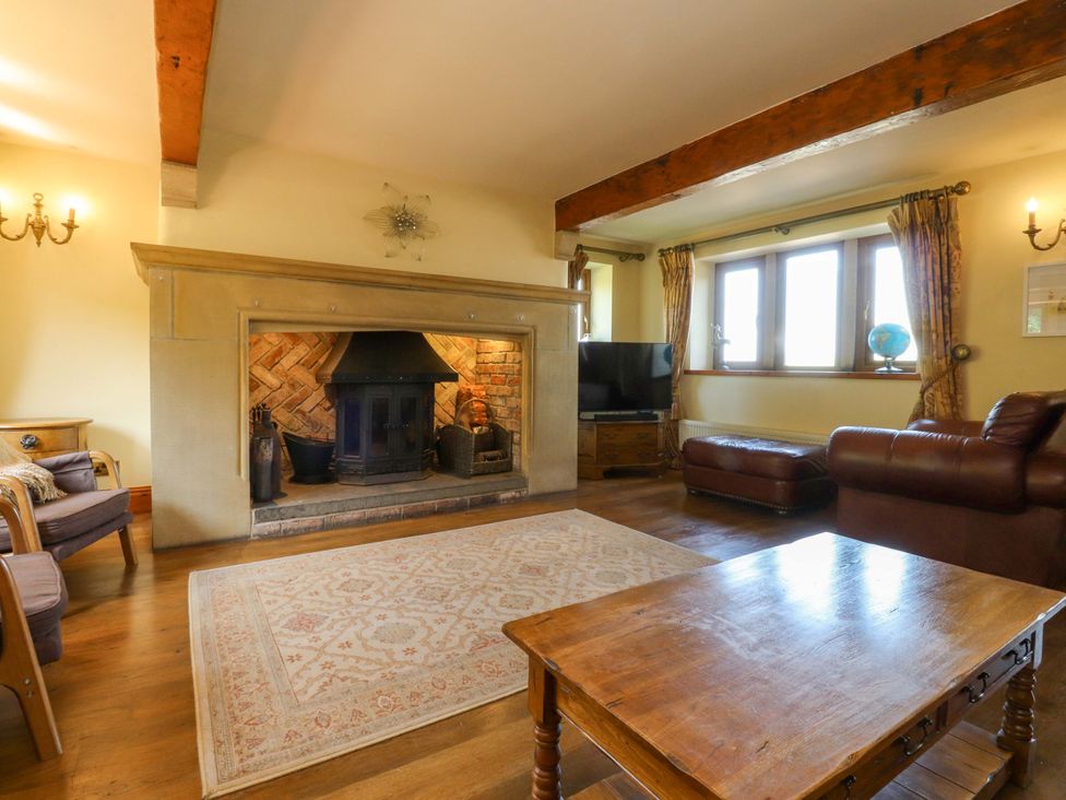 A living room with a fireplace and sofa at Sheephouse Farm in Bacup