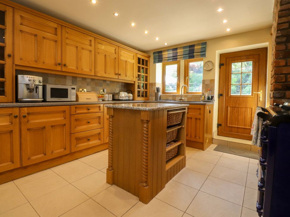 A kitchen with wooden cabinets and an island at Sheephouse Farm in Bacup