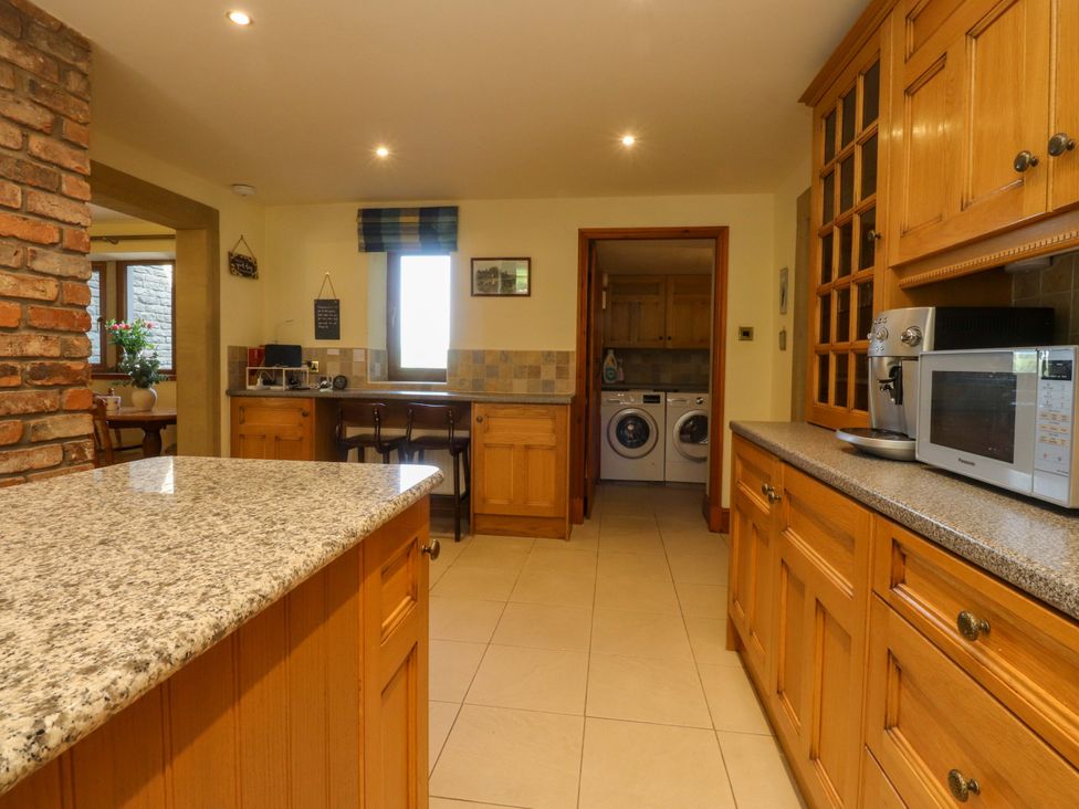 A kitchen with wooden cabinets and appliances at Sheephouse Farm in Bacup