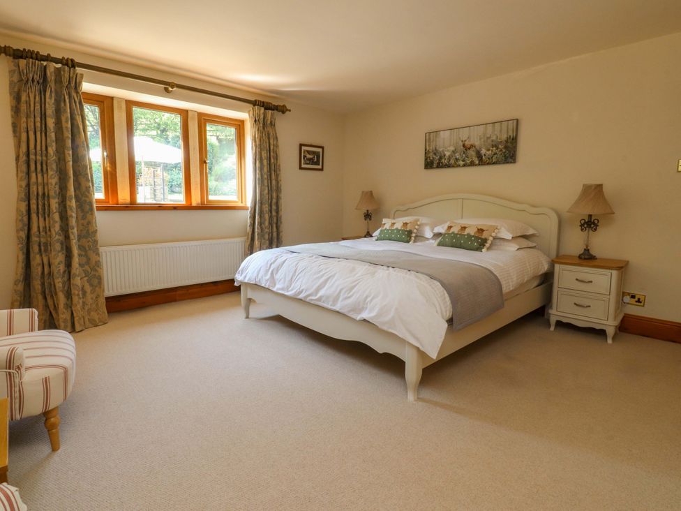 A bedroom with a bed and windows at Sheephouse Farm in Bacup