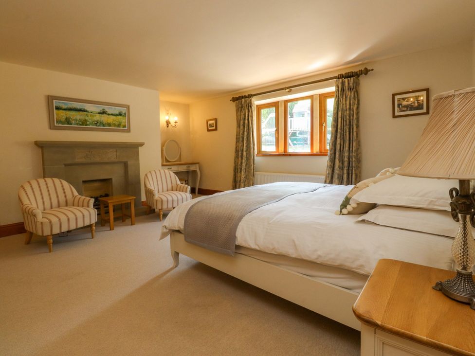 A bedroom with a bed and armchairs at Sheephouse Farm in Bacup