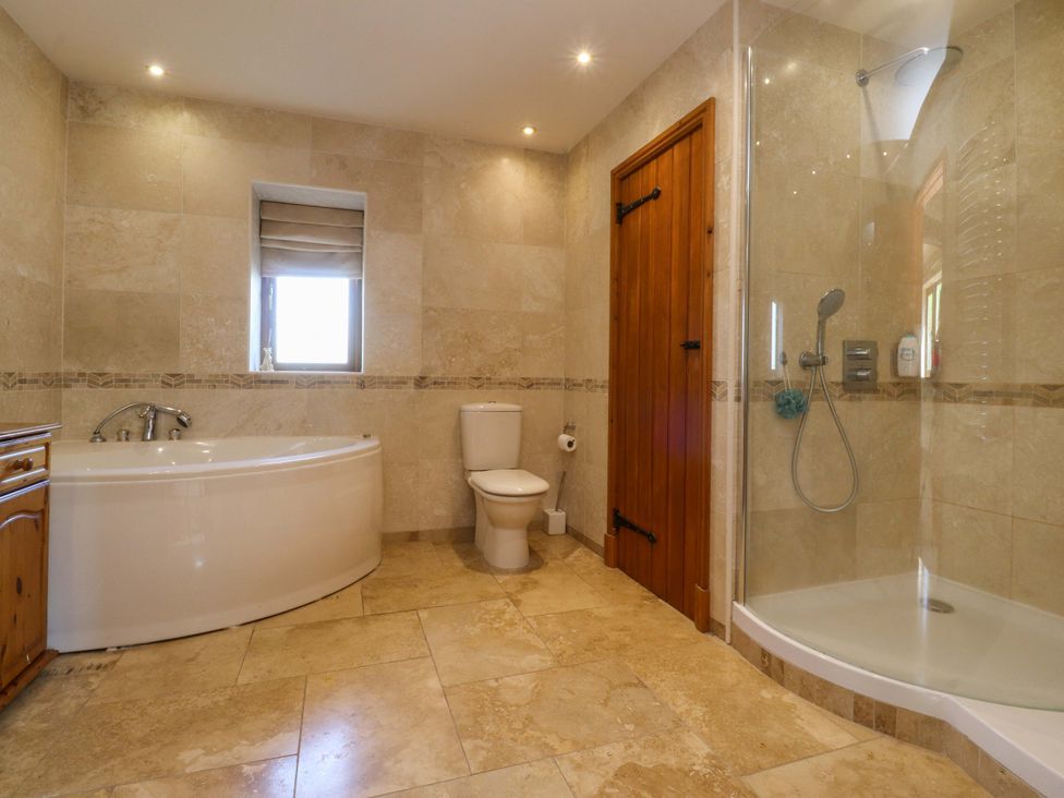 A bathroom with a bathtub and shower at Sheephouse Farm in Bacup