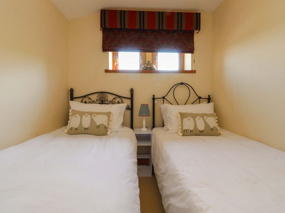 A bedroom with twin beds and a lamp at Sheephouse Farm in Bacup