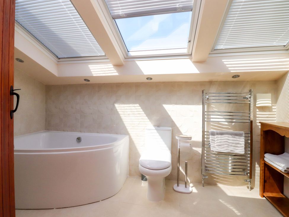 A bathroom with a bathtub and a toilet at Sheephouse Farm in Bacup