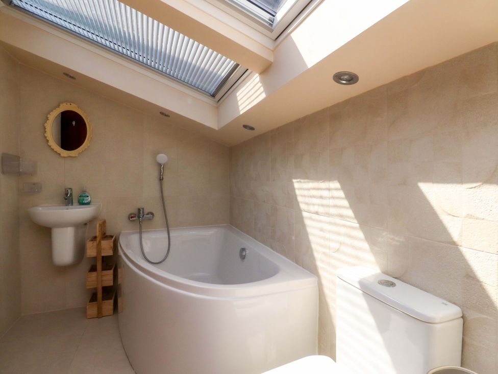 A bathroom with a bath tub, sink and toilet at Sheephouse Farm in Bacup