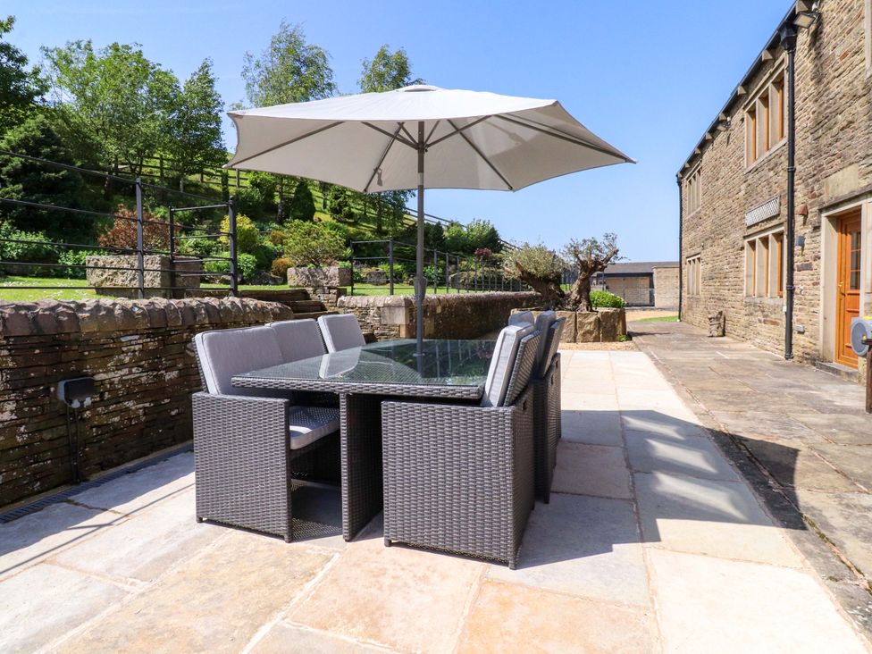 An outdoor dining set with an umbrella at Sheephouse Farm in Bacup