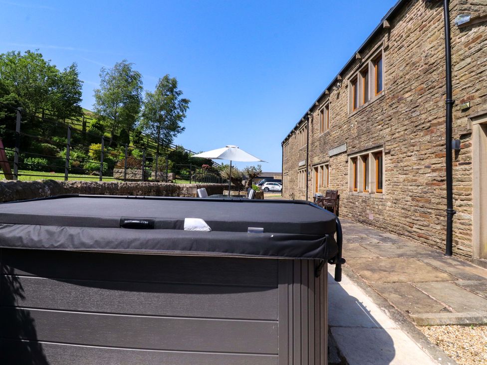 An outdoor area with a hot tub and patio at Sheephouse Farm in Bacup