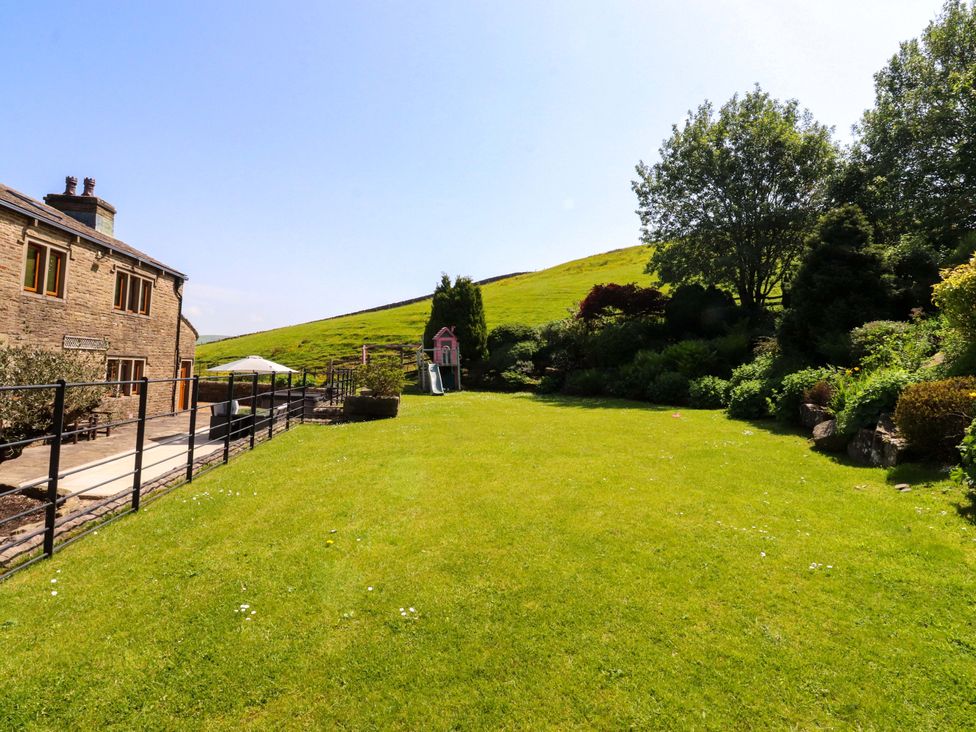 A garden with a house and slide at Sheephouse Farm in Bacup