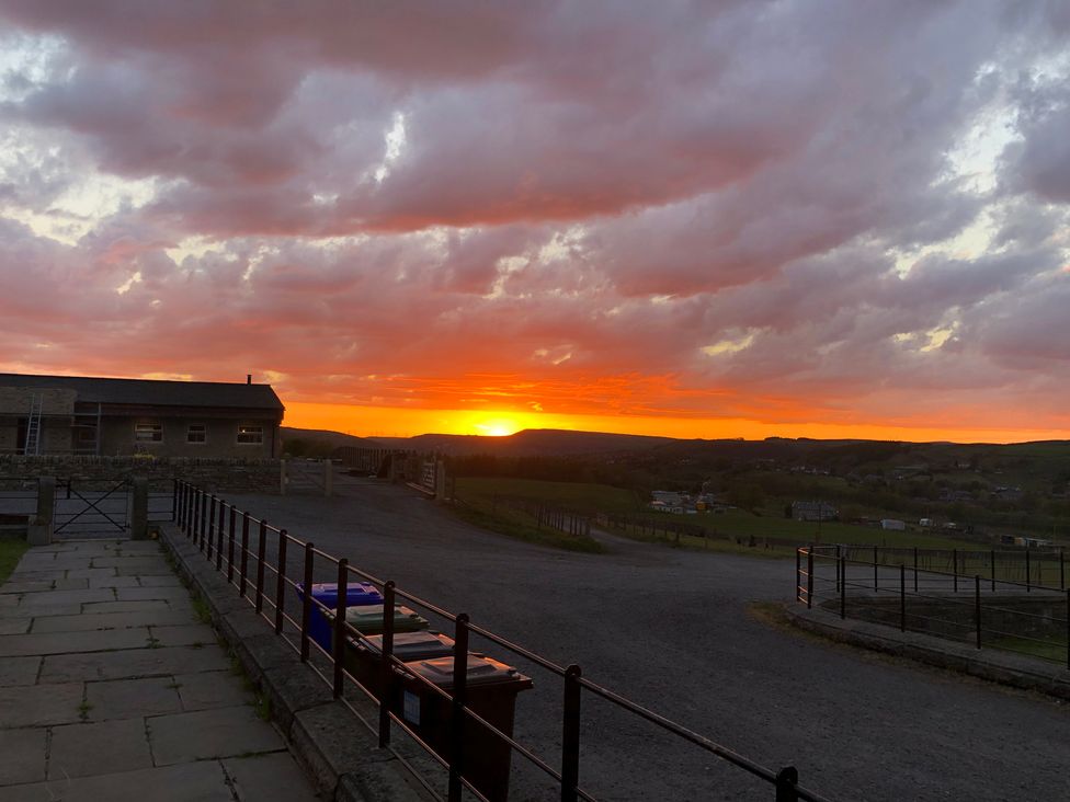A sunset view with clouds and a building at Sheephouse Farm in Bacup