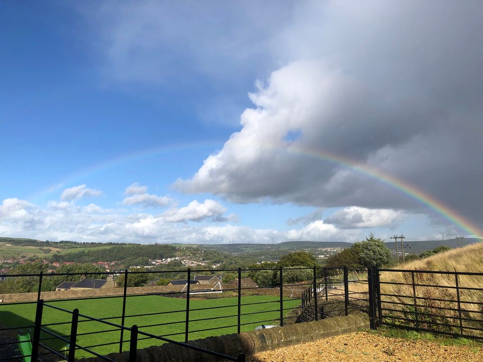A rainbow in the sky over a green field at Sheephouse Farm in Bacup