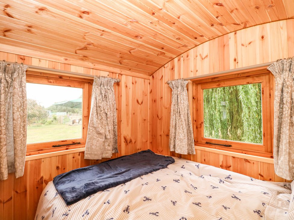 A bedroom with wooden walls and windows at Laurel in Welney near Littleport