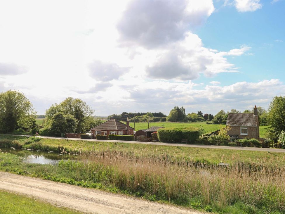 A house with trees and a water body in the background at Laurel in Littleport