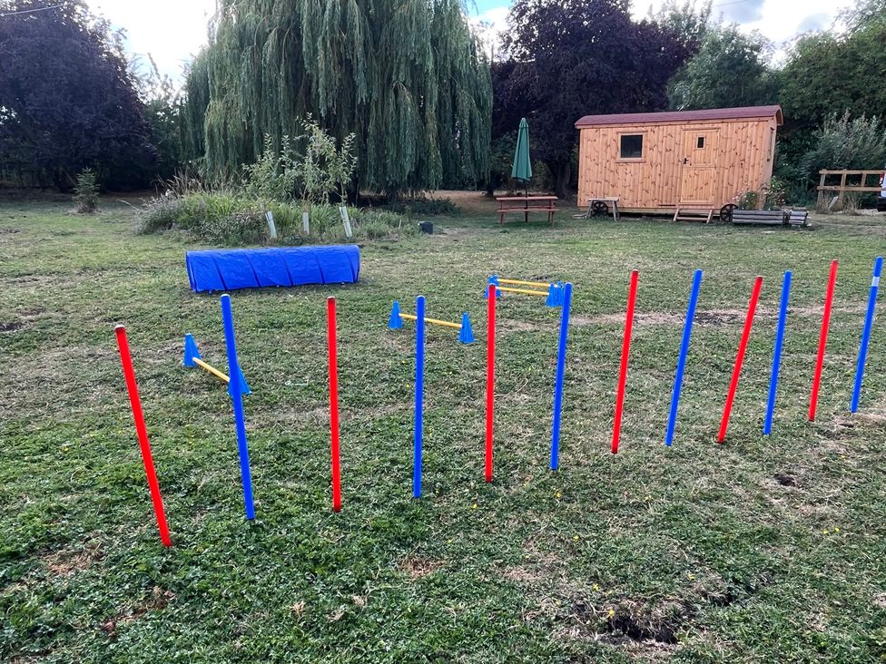 An obstacle course with colored poles and a wooden shed at Laurel in Littleport