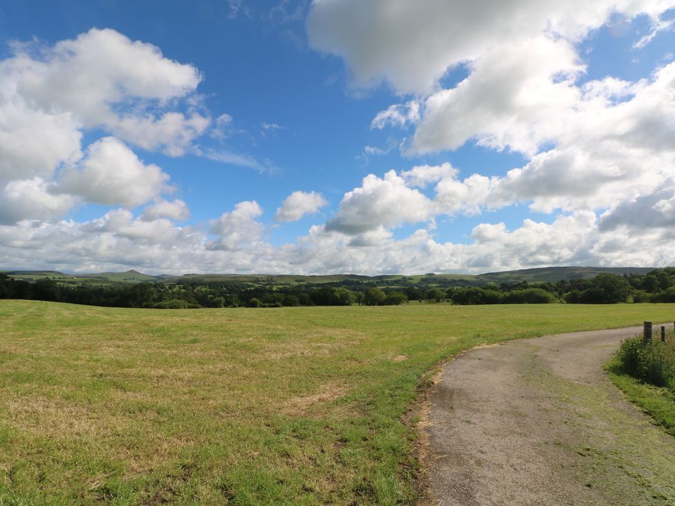 A field with a road and clouds at Hawks View Caravan in Macclesfield