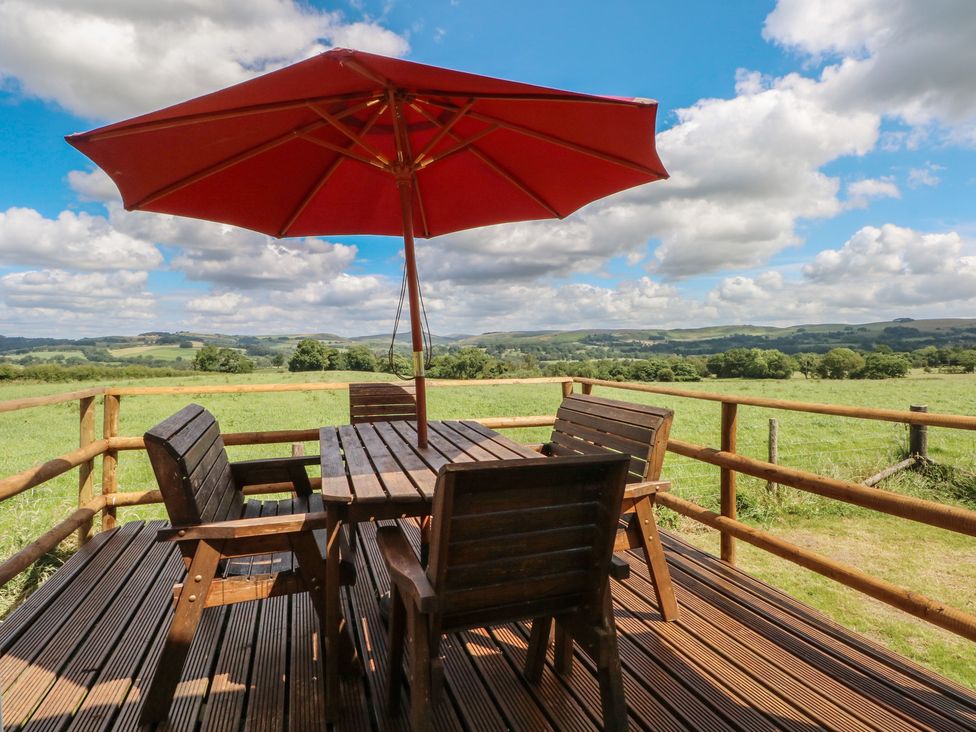 An outdoor patio with a table and chairs at Hawks View Caravan in Leek