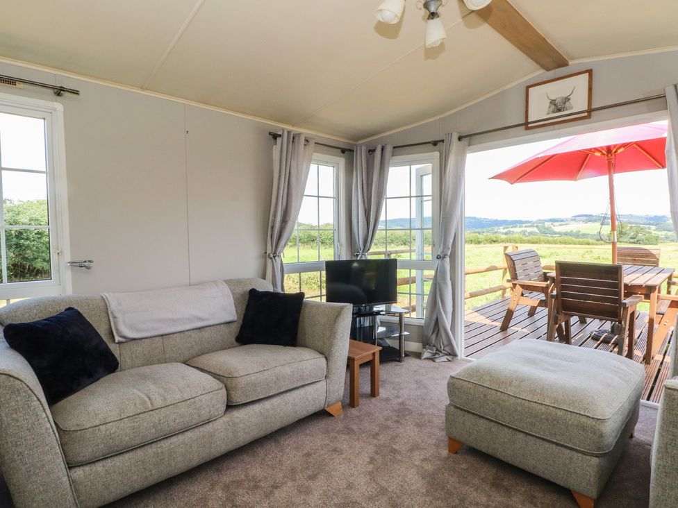 A living room with a sofa and television at Hawks View Caravan in Leek