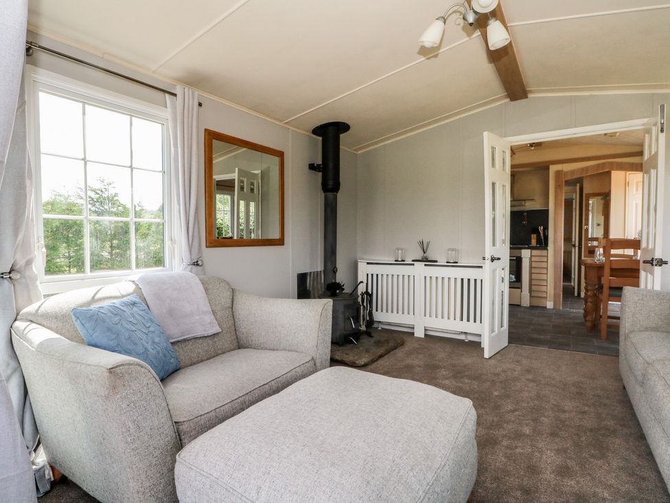 A living room with a sofa and ottoman at Hawks View Caravan in Leek