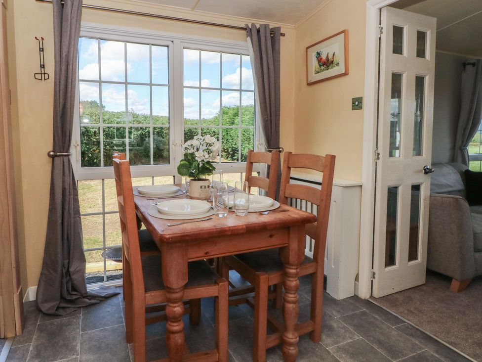 A dining room with a table and chairs at Hawks View Caravan in Leek