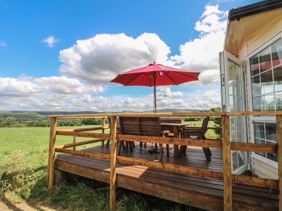 An outdoor seating area with a table and chairs at Hawks View Caravan in Leek
