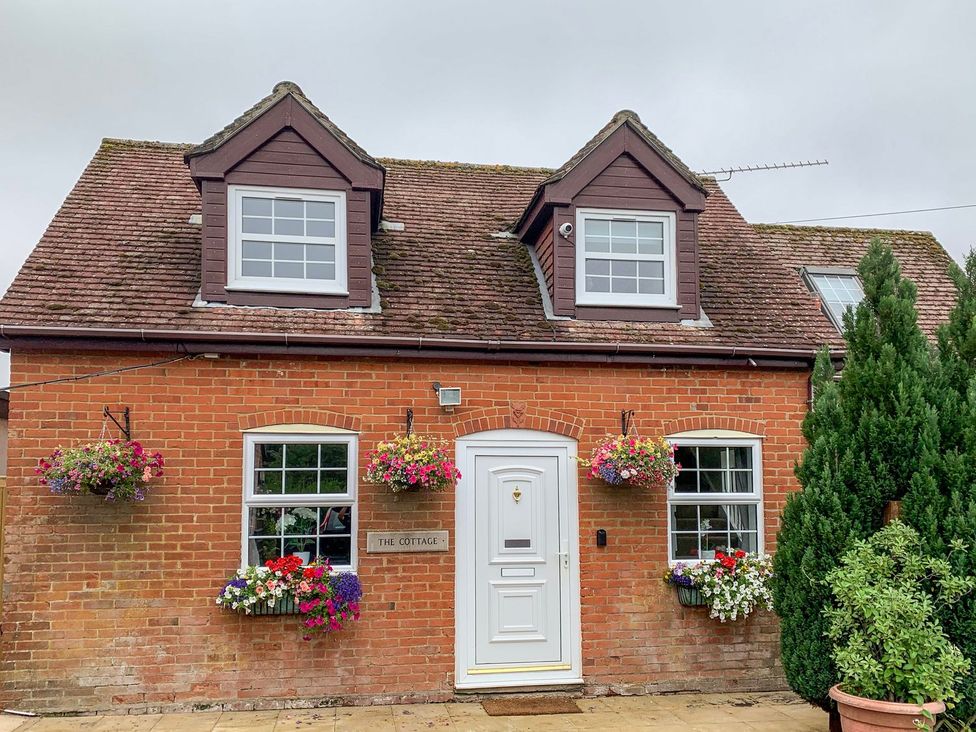 A cottage with flowers and shrubs at The Cottage in Winterslow