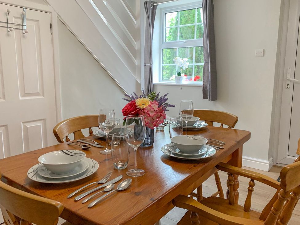 A dining room with a table set for meals at The Cottage in Winterslow