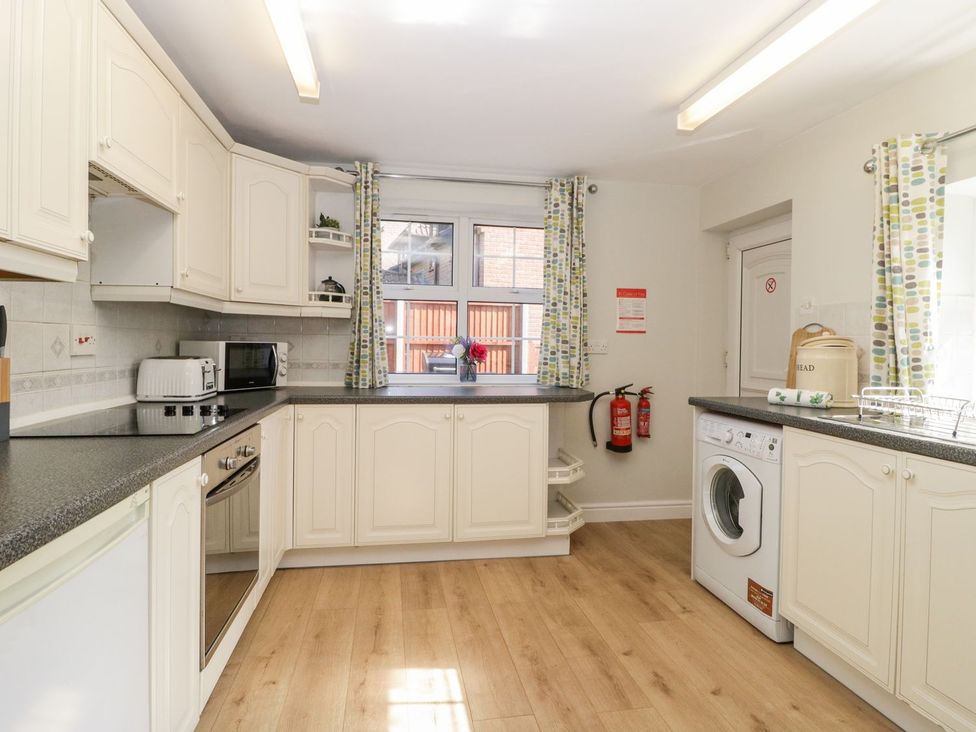 A kitchen with appliances and a window at The Cottage in Winterslow
