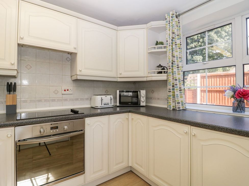 A kitchen with appliances and cabinets at The Cottage in Winterslow