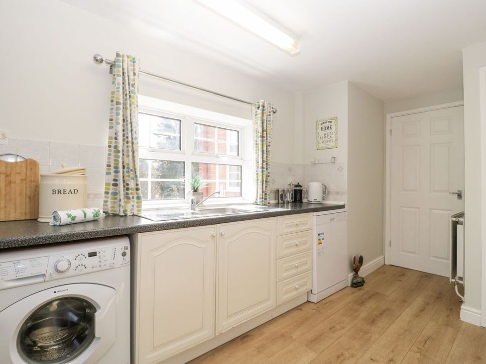 A kitchen with a washing machine and sink at The Cottage in Winterslow