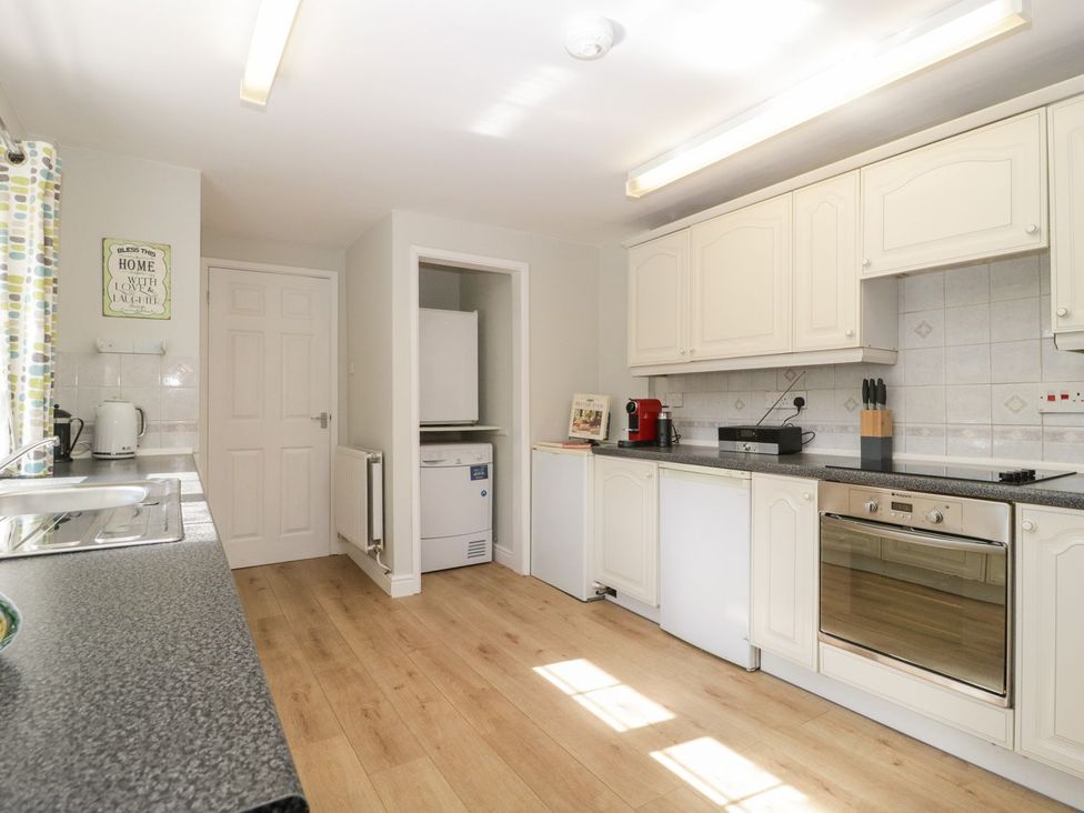 A kitchen with appliances and cabinets at The Cottage in Winterslow