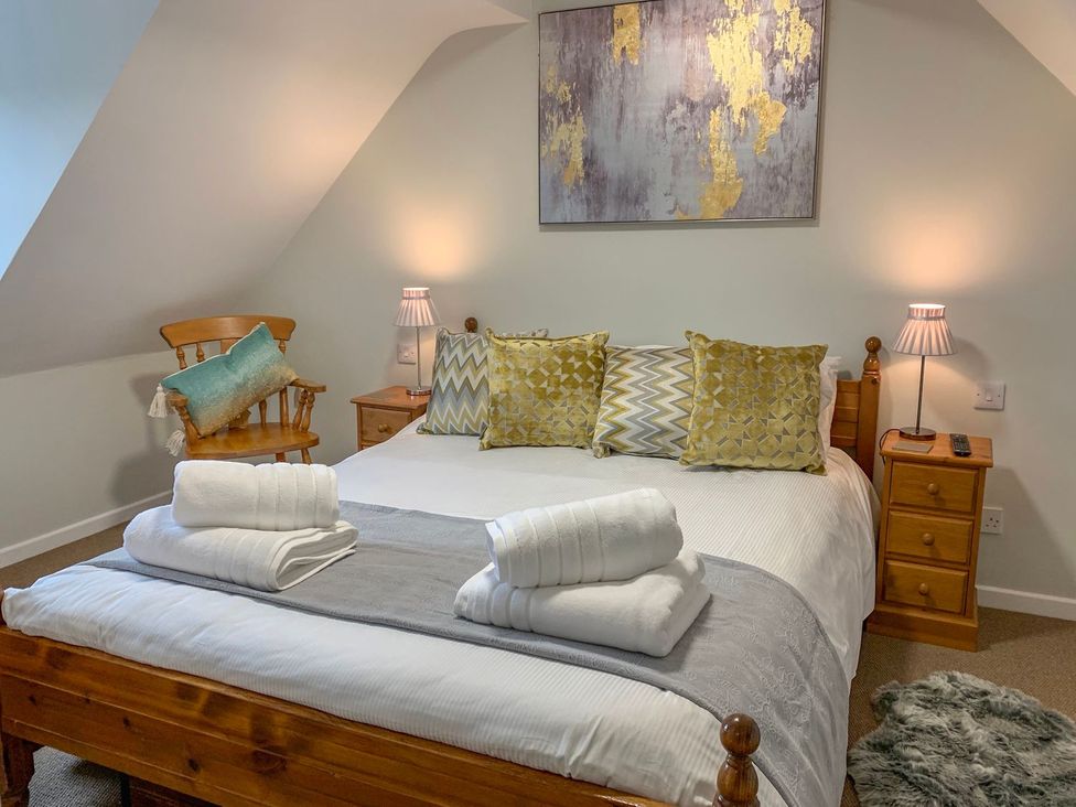 A bedroom with a bed and bedside table at The Cottage in Winterslow