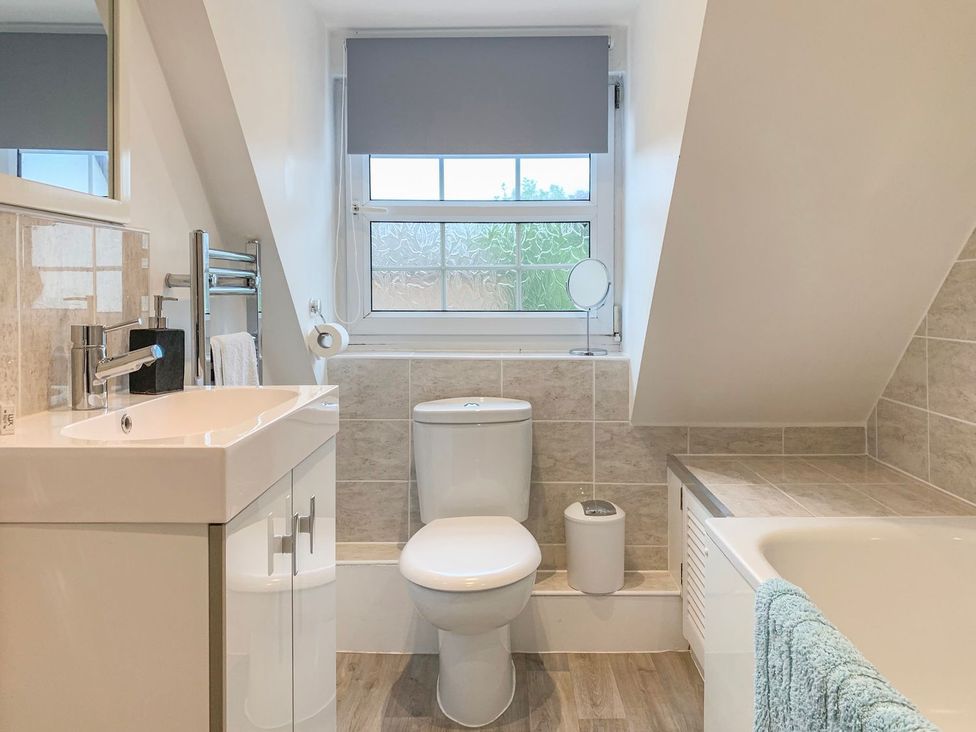 A bathroom with a sink, toilet, and bathtub at The Cottage in Winterslow